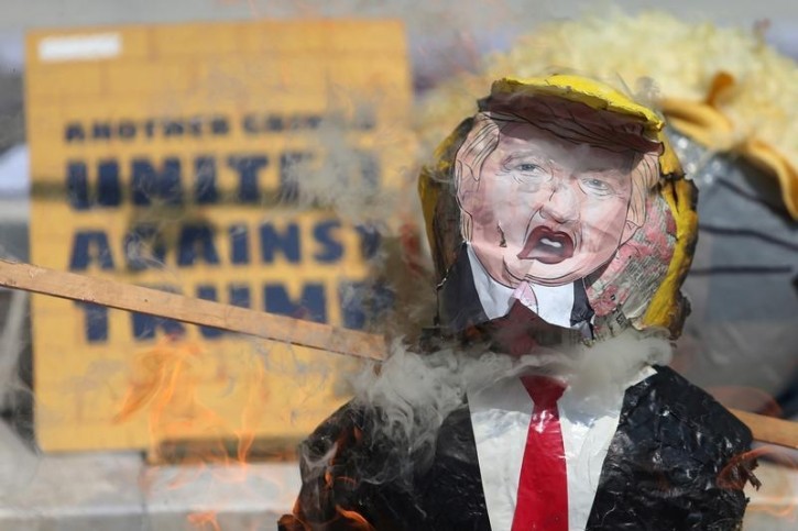 A pinata of U.S. Republican presidential nominee Donald Trump burns during a protest at Hemiciclo a Juarez monument in Mexico City, Mexico, October 12, 2016. REUTERS/Edgard Garrido 