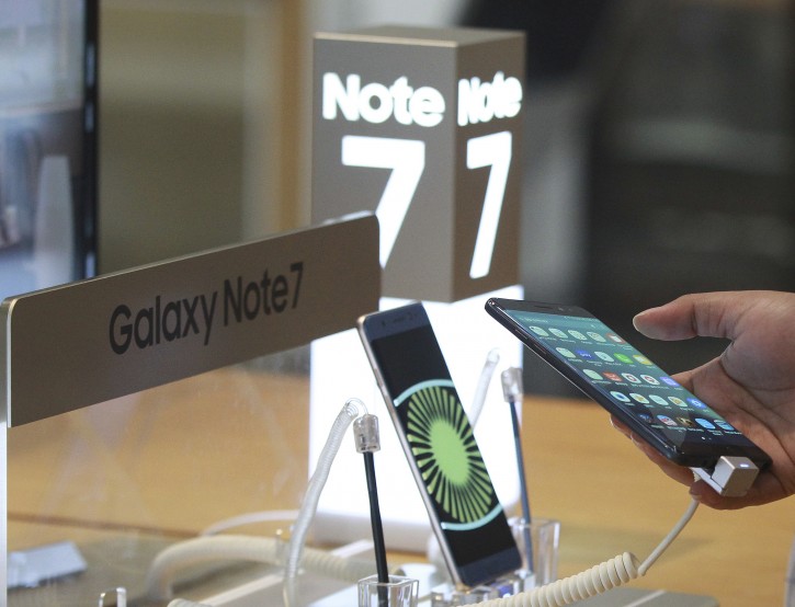 A visitor tries out a Samsung Electronics Galaxy Note 7 smartphone at the company's shop in Seoul in Seoul, South Korea, Monday, Oct. 10, 2016. Samsung Electronics has temporarily halted production of its Galaxy Note 7 smartphones, South Korea's Yonhap news agency reported Monday, following reports that replacements for the fire-prone phones were also overheating. (AP Photo/Ahn Young-joon)