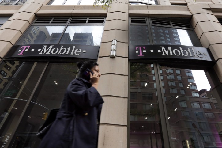 FILE - In this Wednesday, Oct. 14, 2015, file photo, a person passes a T-Mobile store in New York. T-Mobile, the countryâs No. 3 wireless carrier, has been fined $48 million for not clearly telling customers how âunlimitedâ data plans werenât really, well, unlimited. AP