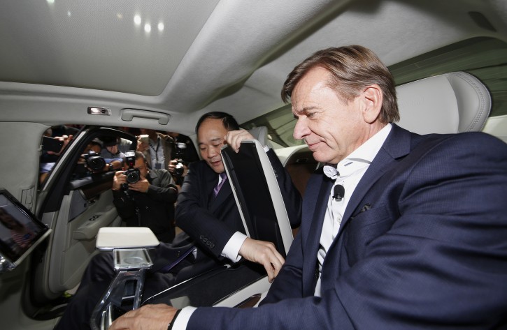 Li Shufu, Chairman of Zhejiang Geely Holdings, left, Hakan Samuelsson, CEO of Volvo Cars, right,  examine the interior of a new S90 Volvo car in Shanghai, China Wednesday Nov. 2, 2016. Volvo Cars and its Chinese owner are revving up their profile as they focus on selling premium cars in world markets. The companies announced a strategy Wednesday that includes a new factory to make vehicles based on a new shared platform, including vehicles for Geely's new "connected car" brand, Lynk & Co.(AP Photo)