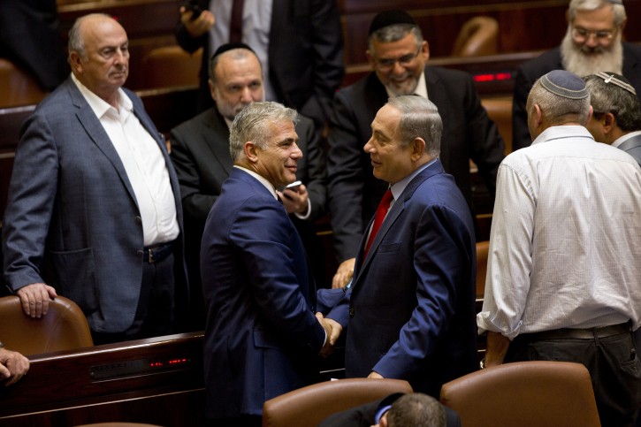In this Monday, Oct. 31, 2016 photo, Israeli Prime Minister Benjamin Netanyahu, center right, shakes hands with Yair Lapid, leader of the Yesh Atid party, during a session at the Knesset, Israel's parliament, in Jerusalem. Lapid believes he has finally found a formula that will allow him to do something that has eluded Israeli politicians for nearly a decade: Defeat Prime Minister Benjamin Netanyahu in an election. Just three years after Lapid gave up a successful media career for the rough-and-tumble of Israeli politics, his centrist Yesh Atid party has been surging in opinion polls -- repeatedly coming out ahead of Netanyahuâs long-dominant Likud Party. (AP Photo/Sebastian Scheiner)