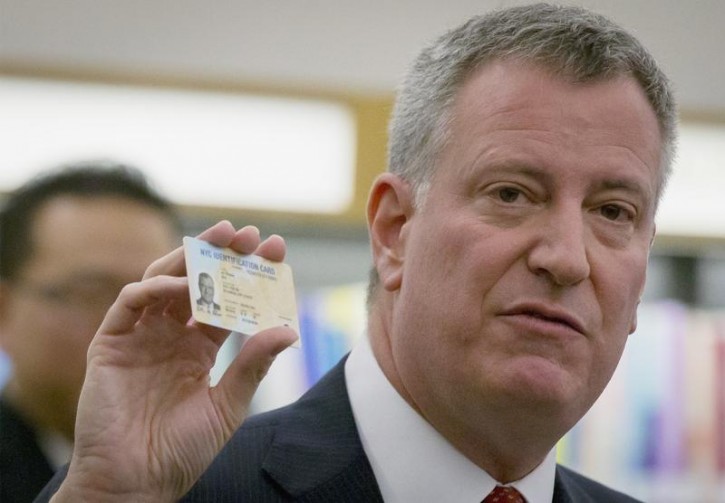 FILE - New York City mayor Bill de Blasio holds his new municipal identification card during a news conference at the Queens Library in the Queens Borough of New York January 12, 2015.  REUTERS/Brendan McDermid