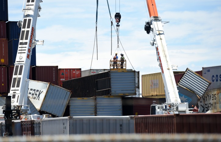 Workers examine toppled shipping containers at the Port of Brisbane, Queensland, Australia, 14 November 2016. Brisbane's air and sea ports are cleaning up after a storm packing wind gusts of almost 160km/h toppled shipping containers and blew planes around on the tarmac on 13 November. EPA/DAN PELED