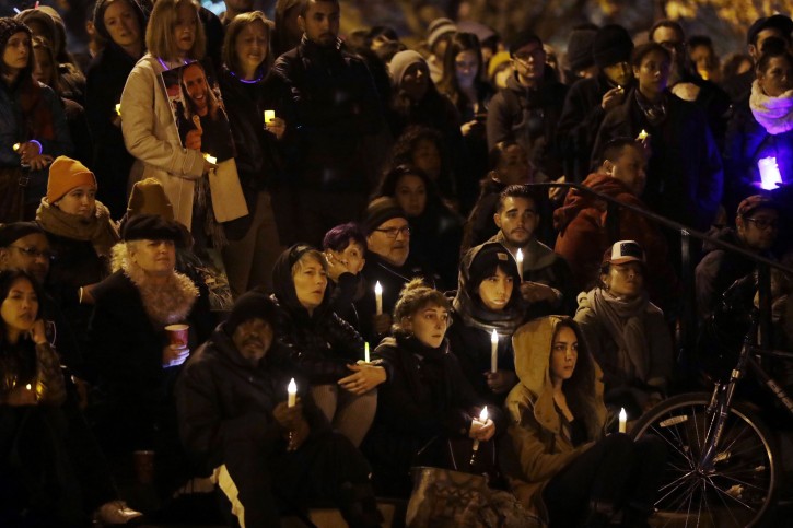 A crowd holds candles during a vigil in memory of victims of a warehouse fire at Lake Merritt Monday, Dec. 5, 2016, in Oakland, Calif. (AP Photo/Marcio Jose Sanchez)