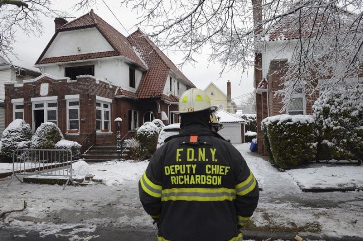 Firefighters stand near the site of a home fire in the Midwood neighborhood of Brooklyn, New York March 21, 2015. Reuters