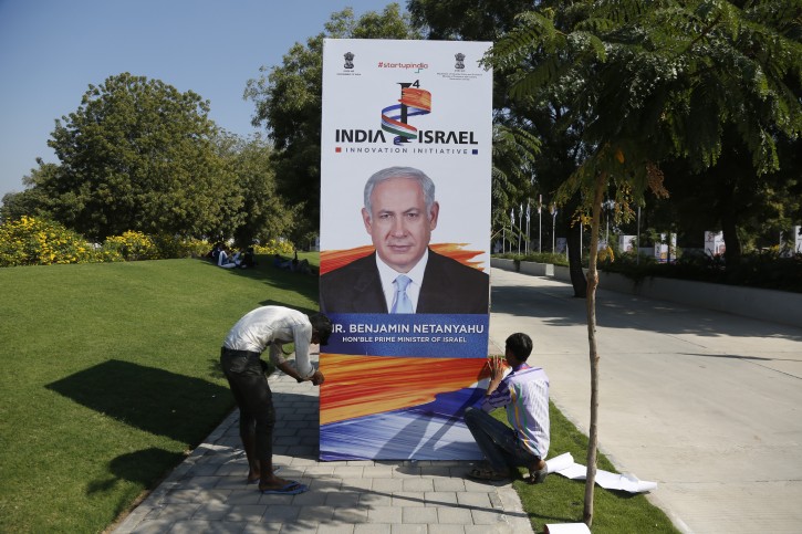 Indian workers put up a hoarding with a photograph of Israeli Prime Minister Benjamin Netanyahu at the International Centre for Entrepreneurship and Technology (iCreate) near Bavla in Ahmadabad, India, Tuesday, Jan. 16, 2018. Indian Prime Minister Narendra Modi and Netanyahu are expected to inaugurate a start-up support center iCreate in presence of nearly 1000 top industrialists on Wednesday. (AP Photo/Ajit Solanki)