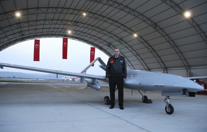 Turkey's President Recep Tayyip Erdogan poses for a photo in front of a drone at a military airbase in Batman, Turkey, Saturday, Feb. 3, 2018. AP