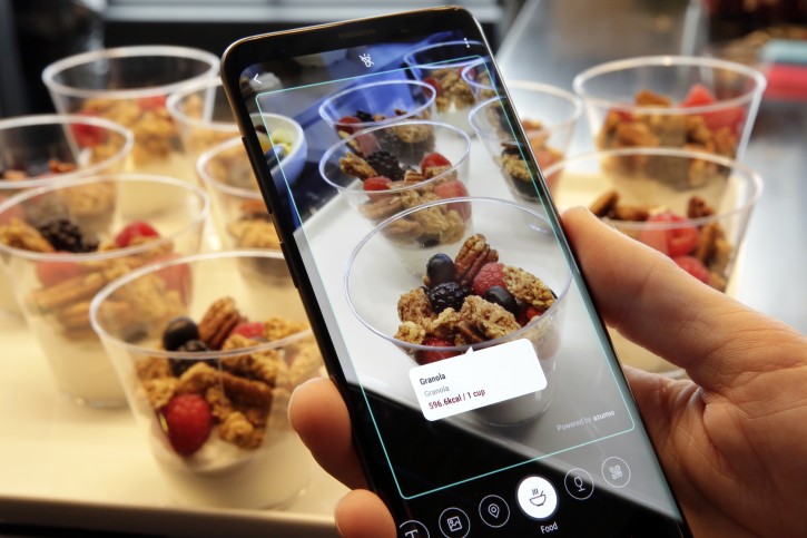 In this Wednesday, Feb. 21, 2018, photo the Bixby virtual assistant software of a Samsung Galaxy S9 Plus mobile phone identifies food and displays its calorie content during a product preview in New York. The Galaxy S9 phones were unveiled Sunday, Feb. 25, in Barcelona, Spain, and will be available March 16. Advance orders begin this Friday. (AP Photo/Richard Drew)