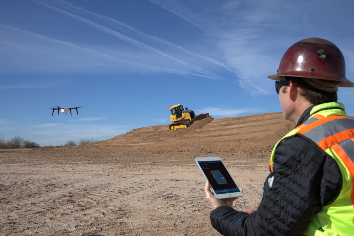 In this undated photo provided by Kespry, an operator monitors a Kespry drone during its autonomous flight. Robots are coming to a construction site near you. Tech startups are developing self-driving bulldozers, survey drones and bricklaying robots to help the construction industry boost productivity, speed and safety as it struggles to find enough skilled workers. (Adam Crowley/Kespry via AP)