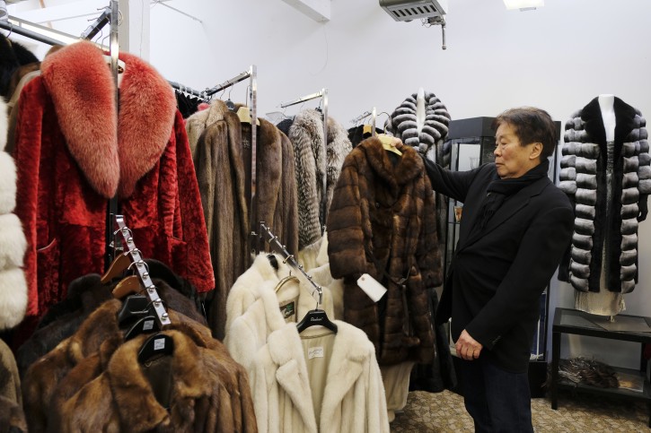 In this photo taken Friday, March 16, 2018, Benjamin Lin holds up a fur coat at the B.B. Hawk showroom in San Francisco. (AP Photo/Eric Risberg)