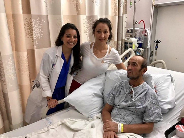 Sabirjon Akhmedov is pictured in bed at St. Luke's Hospital with his daughter Feruza Akhmedova (c.) and Dr. Ayesha Arif (l.), who solved the mystery of his identity. (COURTESY OF AKHMEDOV FAMILY)