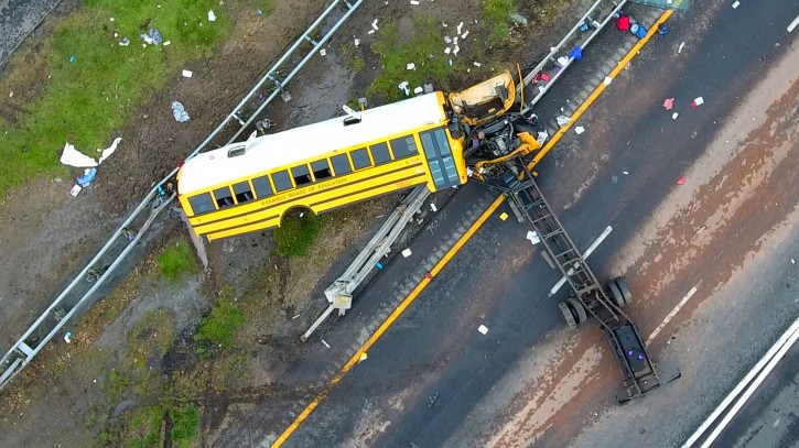 In this aerial photo, a school bus lies crashed on Route 80 in Mount Olive, N.J., Thursday, May 17, 2018. The Paramus school district says the bus was taking students on Thursday from East Brook Middle School to Waterloo Village, a historic site near the crash scene. The yellow school bus was carrying 38 students and seven adults when it crashed, killing a student and a teacher. (Andre Malok/NJ Advance Media via AP)