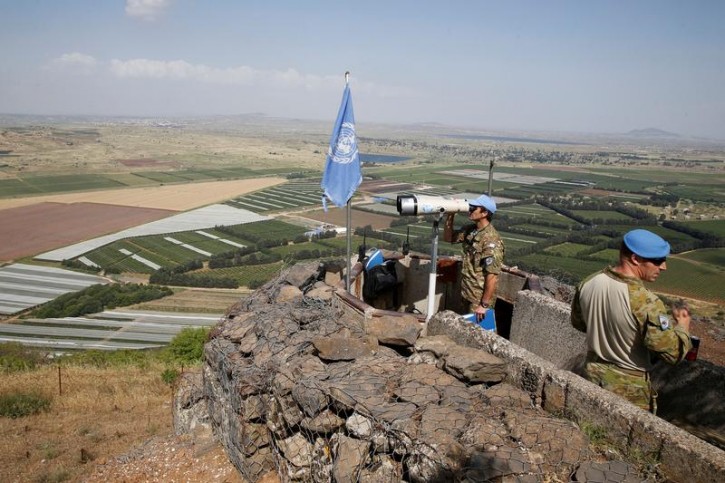 A United Nations Truce Supervision Organisation military observer uses binoculars near the border with Syria in the Israeli-occupied Golan Heights, Israel May 11, 2018. REUTERS/Baz Ratner  