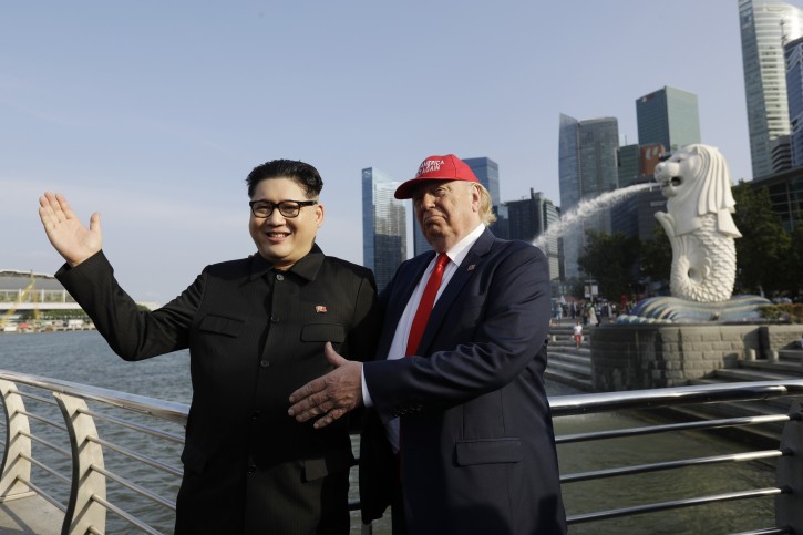 Kim Jong Un and Donald Trump impersonators, Howard X, left, and Dennis Alan, right, pose for photographs at the Merlion Park, a popular tourist destination in Singapore, on Friday, June 8, 2018. Kim Jong Un lookalike who uses the name Howard X said he was detained and questioned upon his arrival in Singapore on Friday, days before a summit between the North Korean leader and President Donald Trump. (AP Photo/Wong Maye-E)