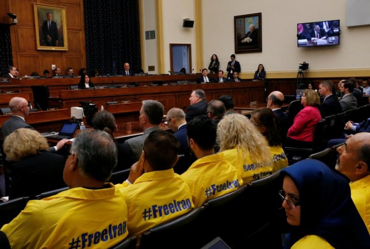 U.S. Secretary of State Mike Pompeo testifies at a hearing of the U.S. House Foreign Affairs Committee as people sit in the audience behind him wearing "#FreeIran" jackets on Capitol Hill in Washington, U.S., May 23, 2018. REUTERS/Leah Millis