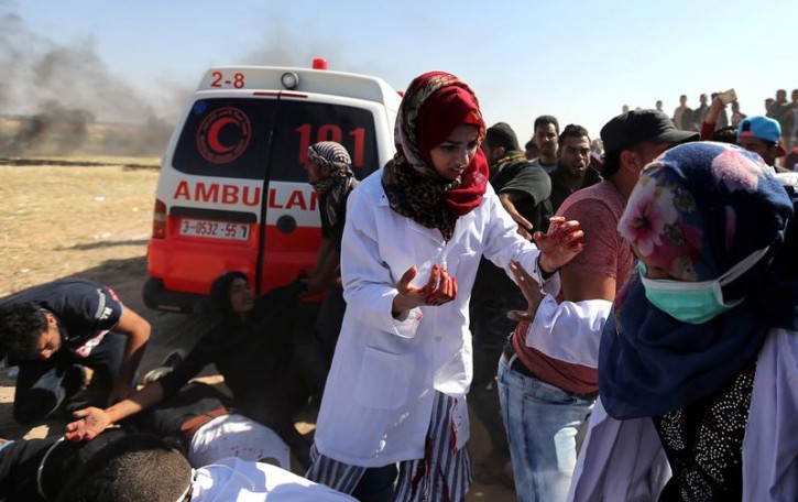 FILE - Female Palestinian medic Razan Al-Najar works at the scene of clashes at Israel-Gaza border, in the southern Gaza Strip April 1, 2018. Reuters