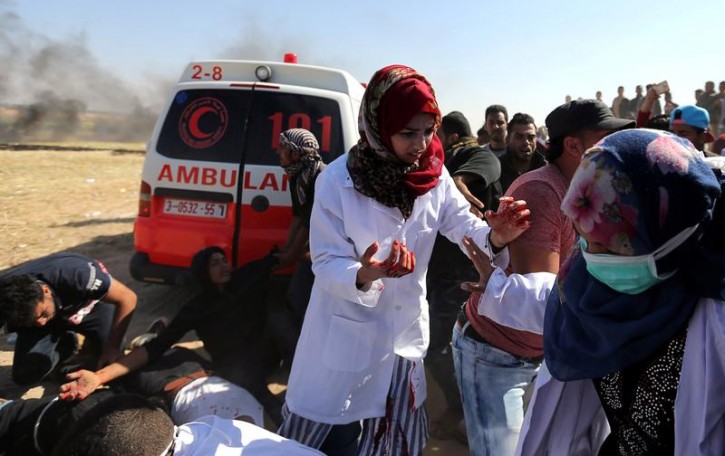 FILE -  Female Palestinian medic Razan Al-Najar works at the scene of clashes at Israel-Gaza border, in the southern Gaza Strip April 1, 2018. Reuters