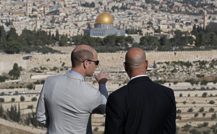 Britain's Prince William (L) talks to a guide (R) in the Mount of Olives overlooking the Old City with the golden dome of the Dome of the Rock mosque, in Jerusalem, 28 June 2018. The Duke of Cambridge is the first member of the royal family to make an official visit to the Jewish state and the Palestinian territories. EPA-EFE/THOMAS COEX / POOL