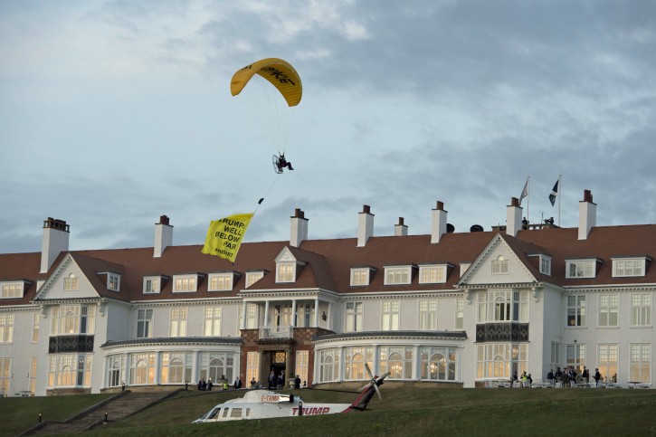 A Greenpeace protester flying a microlight passes over Donald Trump's resort in Turnberry, South Ayrshire, with a banner reading "Trump: Well Below Par", shortly after the US President arrived at the hotel. PRESS ASSOCIATION Photo