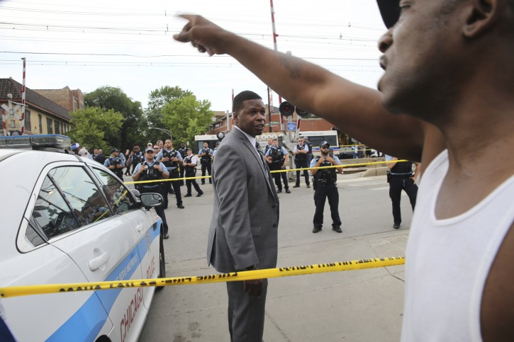 Members of the Chicago police department and an angry crowd, at the scene of a police involved shooting in the 7100 block of South Chappel Ave., in Chicago, on Saturday July 14, 2018.