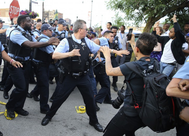 Members of the Chicago police department and an angry crowd, at the scene of a police involved shooting in the 7100 block of South Chappel Ave., in Chicago, on Saturday July 14, 2018. (Nuccio DiNuzzo/Chicago Tribune/AP)