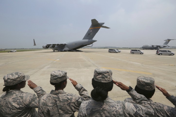 U.S. Army soldiers salute as vehicles carry remains believed to be from American servicemen killed during the 1950-53 Korean War after arrived from North Korea, at Osan Air Base in Pyeongtaek, South Korea, Friday, July 27, 2018. (AP Photo/Ahn Young-joon. Pool)