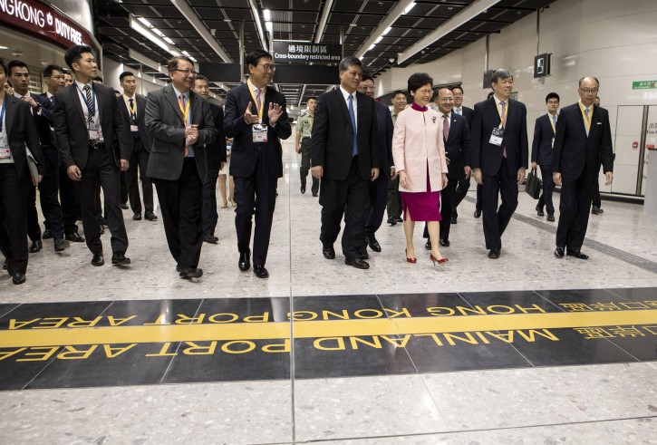 Frank Chan, Hong Kong's transport and housing secretary, front row right, Carrie Lam, Hong Kong's chief executive, front row third right, Ma Xingrui, governor of Guangdong Province, front row fourth right, Frederick Ma, chairman of MTR Corp., front row fourth left, and guests arrive to the border line into China during a tour in the Hong Kong Port Area at West Kowloon Station, which houses the terminal for the Guangzhou-Shenzhen-Hong Kong Express Rail Link (XRL), developed by MTR Corp., in Hong Kong, China, on Saturday, Sept. 22, 2018. AP