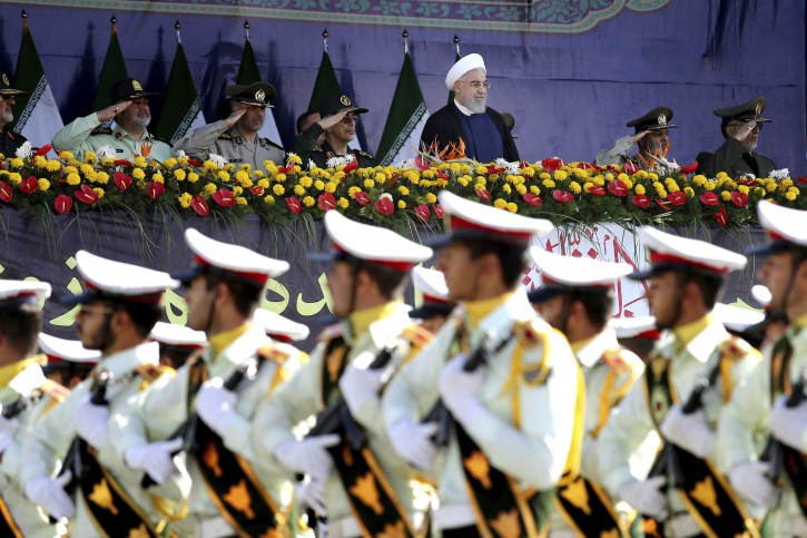 Iran's President Hassan Rouhani, top center, reviews army troops marching during the 38th anniversary of Iraq's 1980 invasion of Iran, in front of the shrine of the late revolutionary founder, Ayatollah Khomeini, just outside Tehran, Iran, Saturday, Sept. 22, 2018. AP