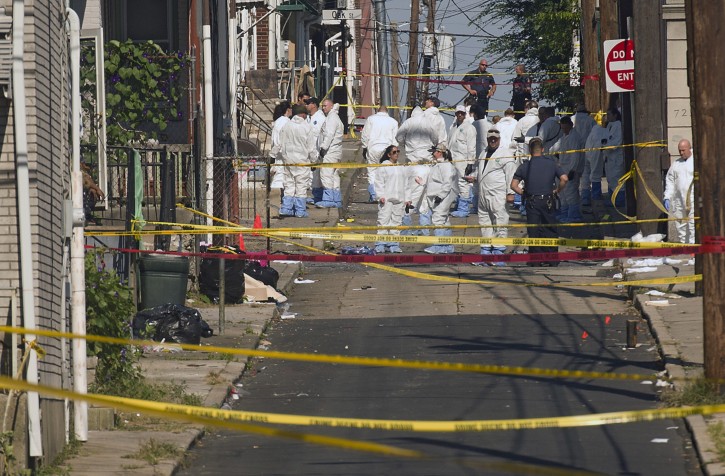 Police join members of the ATF and the FBI as they investigate North Hall Street in Allentown, Pa., Sunday, Sept. 30, 2018, after a fiery car explosion rocked the neighborhood on Saturday. Police confirmed at least one fatality and at least 50 investigators remain on the scene scouring for evidence. (Harry Fisher/The Morning Call via AP)