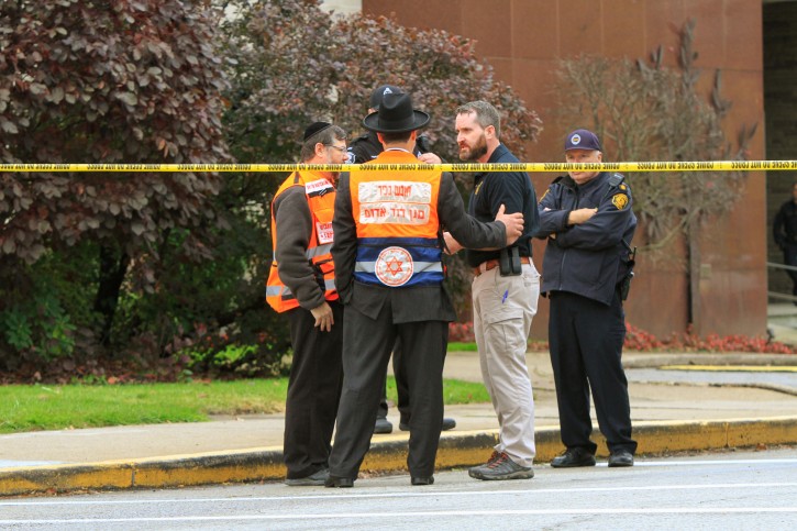 Police officers guarding the Tree of Life synagogue following shooting at the synagogue, speak with men in orange vest from a Jewish burial society in Pittsburgh, Pennsylvania, U.S., October 27, 2018.   REUTERS/John Altdorferâ?¨