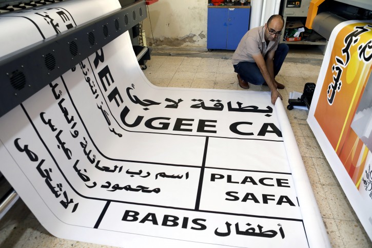 A Palestinian worker prints a huge refugee card for President Mahmoud Abbas to show solidarity ahead of his speech at the 73rd UN General Assembly session, in the West Bank city of Bethlehem, 25 September 2018. EPA