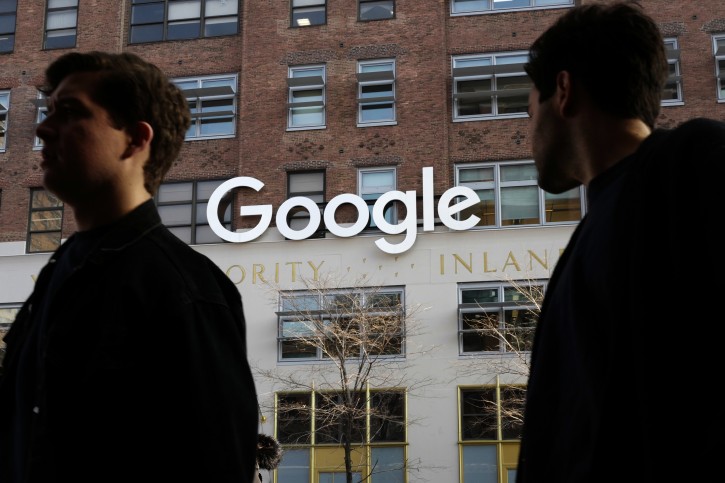 In this Dec. 4, 2017, photo, people walk by Google offices in New York. (AP Photo/Mark Lennihan)