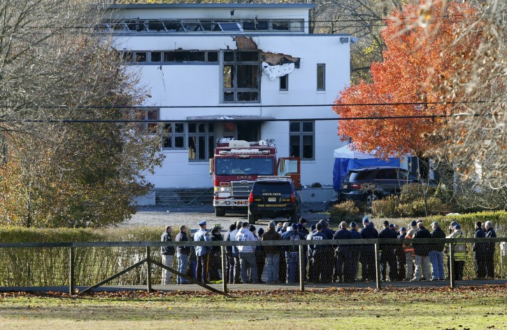 FILE - In this  Nov. 21, 2018 file photo, authorities gather in Colts Neck, N.J., to investigate the aftermath of fatal fire that killed two children and two adults. The bodies of Keith Caneiro, his wife Jennifer Caneiro, their children Jesse, 11, and Sophia 8, were found at the scene: all victims of an apparent homicide.   (AP Photo/Noah K. Murray, File)