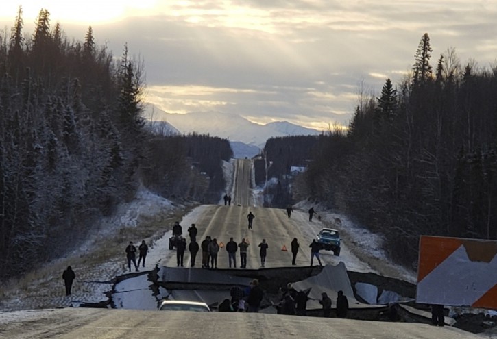 In this photo provided by Jonathan M. Lettow, people walk along Vine Road after an earthquake, Friday, Nov. 30, 2018, in Wasilla, Alaska. Back-to-back earthquakes measuring 7.0 and 5.7 rocked buildings and shattered roads Friday morning in Anchorage, sending people running into the streets and briefly triggering a warning to residents in Kodiak to flee to higher ground for fear of a tsunami. (Jonathan M. Lettow via AP)