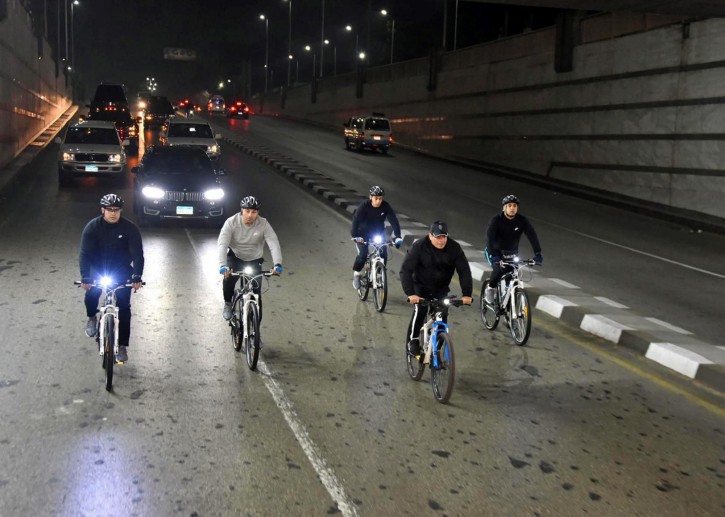 In this Dec. 16, 2018 photo released by the Egyptian Presidency, Egyptian President Abdel-Fattah el-Sissi rides his bike to the national Military Academy, in a suburb of Cairo, Egypt. AP