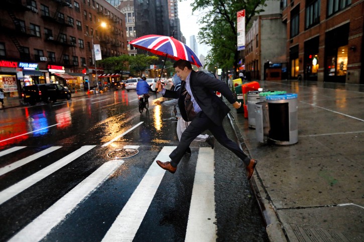 FILE - A man leaps over a rain soaked Tenth Avenue at 57th Street during severe thunderstorm in New York City, New York, USA, 15 May 2018. EPA