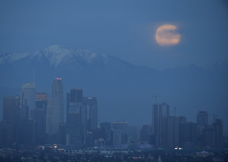 A 'Super Moon' rises behind downtown Los Angeles skyline is seen from Kenneth Hanh Park in Los Angeles, Sunday Jan. 20, 2019. (AP Photo/Ringo H.W. Chiu)