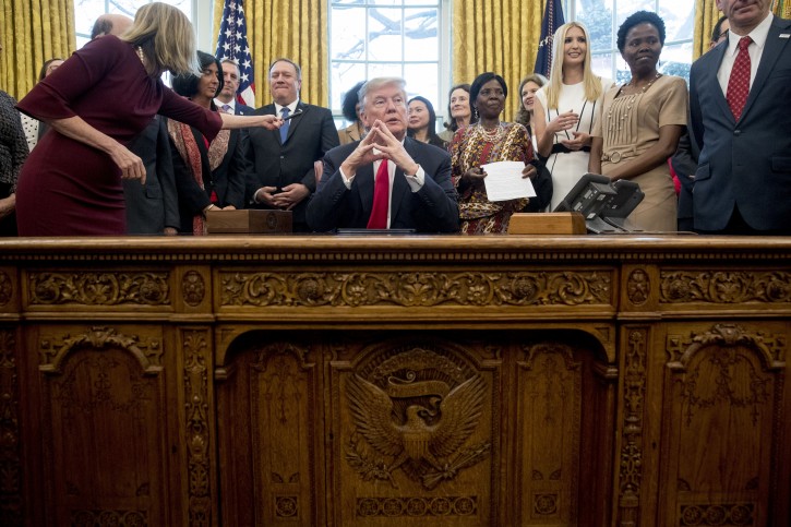 President Donald Trump listens to a question from a reporter after signing the National Security Presidential Memorandum to Launch the "Women's Global Development and Prosperity" Initiative in the Oval Office of the White House in Washington, Thursday, Feb. 7, 2019. Also pictured is Secretary of State Mike Pompeo, center left, and Ivanka Trump, the daughter of President Donald Trump, third from right. (AP Photo/Andrew Harnik)
