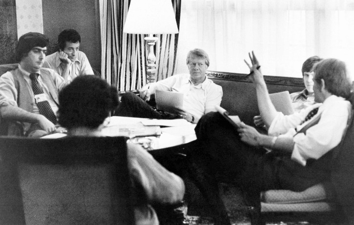 Jimmy Carter meets with his staff at the Americana Hotel in New York on Tuesday, July 14, 1976. From left facing camera: Pat Caddell; Jerry Rafshoon; Carter; his son, Chip and Jody Powell. Back to camera is Pat Anderson. (AP Photo)