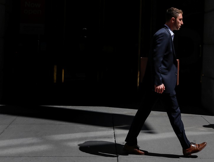 A man in a suit walks on Wall St. in New York City, U.S., August 23, 2018. REUTERS/Brendan McDermid