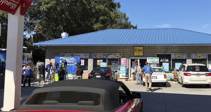 FILE - In this Oct. 24, 2018, file photo, media, at left, record people entering the KC Mart in Simpsonville, S.C., after it was announced the winning Mega Millions lottery ticket was purchased at the store. The South Carolina lottery says a single winner has stepped forward to claim the $1.5 billion Jackpot from a drawing last October. A lottery commission statement says the person submitting the claim for what was the second-largest lottery in U.S. history has chosen to remain anonymous. (AP Photo/Jeffrey Collins, File)