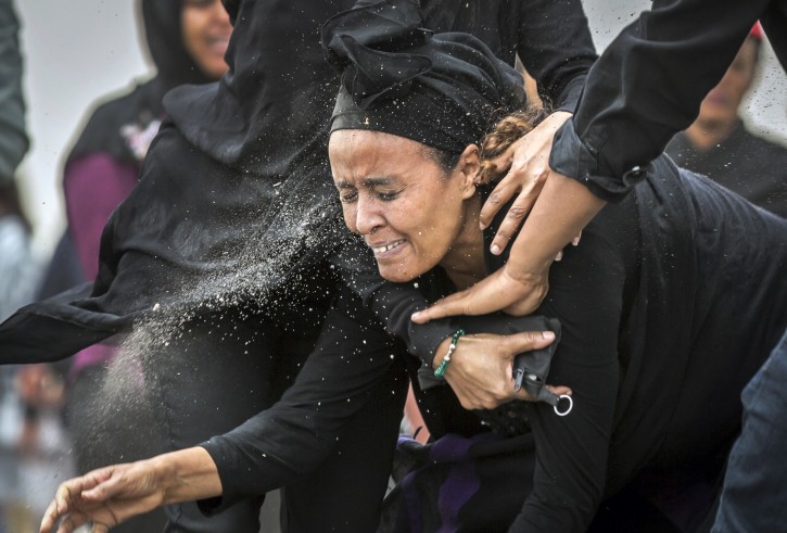 An Ethiopian relative of a crash victim throws dirt in her own face after realising that there is nothing physical left of her loved one, as she mourns and grieves at the scene where the Ethiopian Airlines Boeing 737 Max 8 crashed shortly after takeoff on Sunday killing all 157 on board, near Bishoftu, south-east of Addis Ababa, in Ethiopia Thursday, March 14, 2019. 