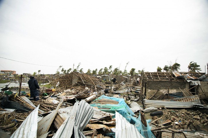 In this photo taken on Friday, March 15, 2019 and provided by the International Red Cross, a man searches through the rubble after Tropical Cyclone Idai, in Beira, Mozambique. Mozambique's President Filipe Nyusi says that more than 1,000 may have by killed by Cyclone Idai, which many say is the worst in more than 20 years. Speaking to state Radio Mozambique, Nyusi said Monday, March 18 that although the official death count is currently 84, he believes the toll will be more than 1,000. (Denis Onyodi/IFRC via AP)