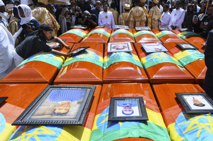 A family member reaches over to a symbolic coffin as she and others attend a burial service for the victims of the Ethiopian Airlines plane crash at the Holy Trinity Cathedral in Addis Ababa, Ethiopia, 17 March 2019. EPA