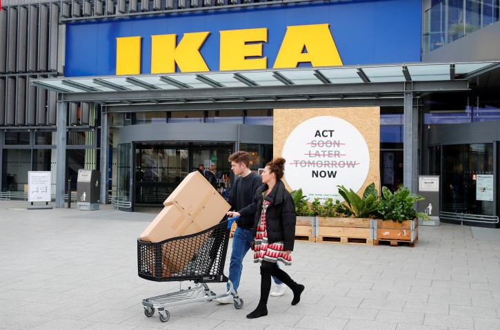 FILE - Customers walk by a placard reading "Act Now" as they leave the IKEA store in Kaarst near Duesseldorf, Germany, April 3, 2019. REUTERS