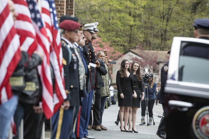 Beth Regan, with her sister Sarah Regan by her side, cries as the casket of her friend, Marine Private First Class Robert Graham, is delivered to St. Elizabeth Ann Seton Church on Friday, April 26, 2019 in Shrub Oak, NY. Graham, who died at 97 has no living family members but Regan arranged for hundreds to attend his funeral. (AP Photo/Allyse Pulliam)