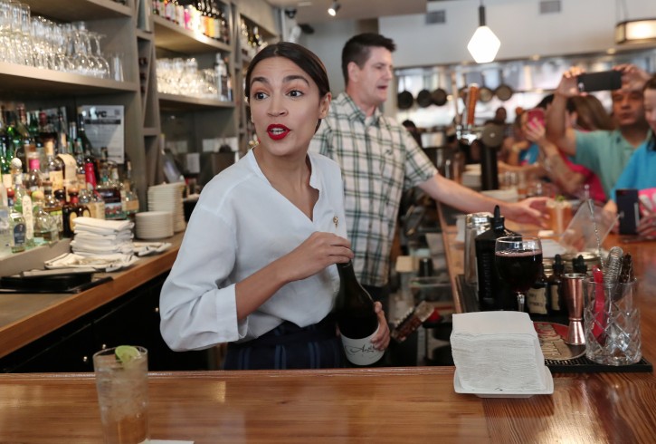 Rep. Alexandria Ocasio-Cortez (D-NY) serves drinks in support of One Fair Wage, a policy that would allow tipped workers to receive full minimum wage plus their tips in New York, at The Queensboro restaurant in the Queens borough of New York, U.S., May 31, 2019. REUTERS/Shannon Stapleton
