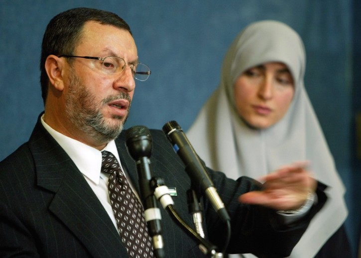 FILE - In this Feb. 16, 2004 file photo,  Abdelhaleem Ashqar, left, with his wife Asma, right, meets reporters at the National Press Club in Washington, to announce his presidential candidacy for the Palestinian National Authority. AP