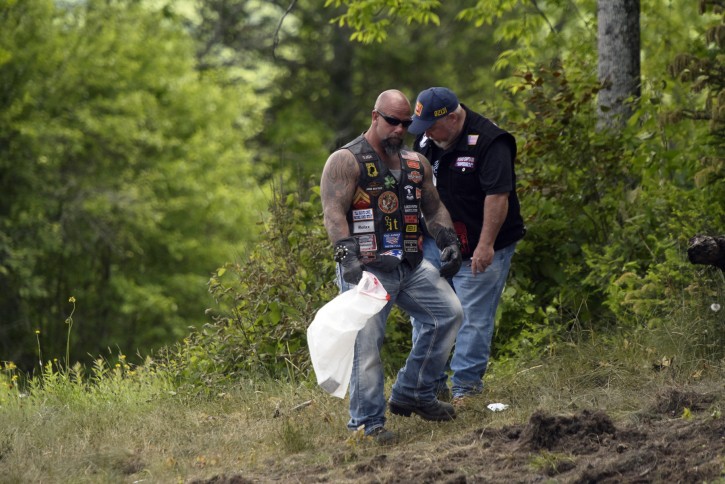 Motorcyclists recover personal items from the scene of a fatal accident on Route 2 in Randolph, N.H., Saturday, June 22, 2019. AP