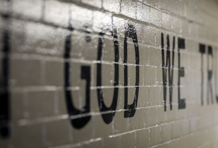 This July 23, 2019 photo shows "In God We Trust" stenciled in a wall at South Park Elementary in Rapid City, S.D. When students return to public schools across South Dakota this fall there should be a new message displayed in a common area, a cafeteria, entryway or other prominent location.(Adam Fondren/Rapid City Journal via AP)